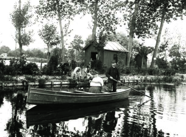 Le poète picard Édouard David et son épouse, dans une barque, devant une parcelle des Hortillonnages © Archives municipales et communautaires d'Amiens_10Z3173
